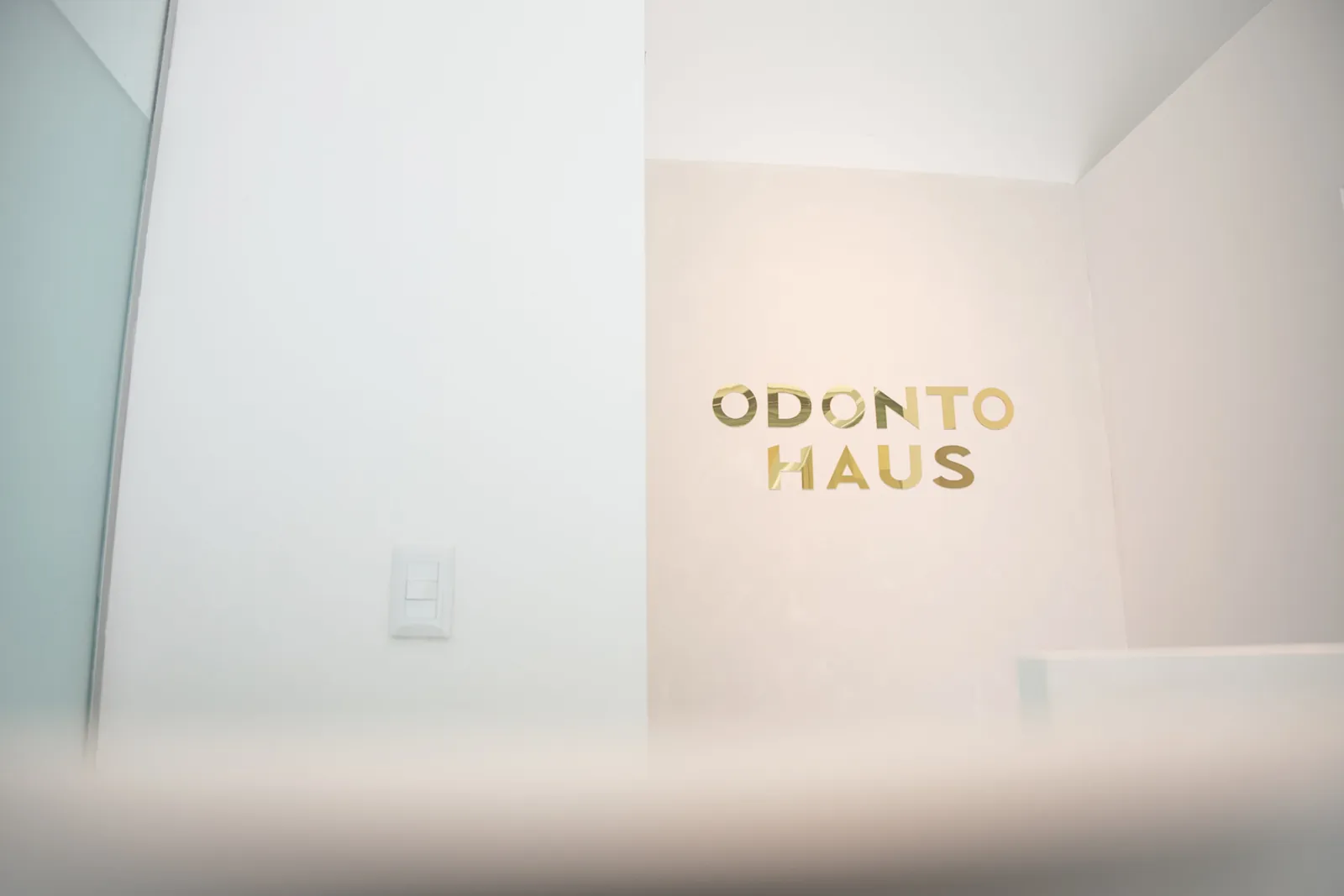 Logo de OdontoHaus en la pared de la clínica